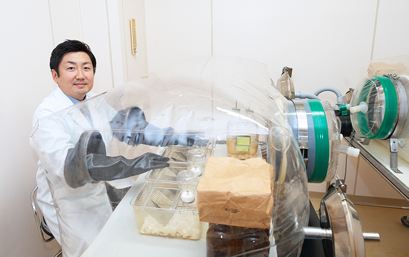 無菌マウスを用いた実験用装置を操作する竹脇研究員