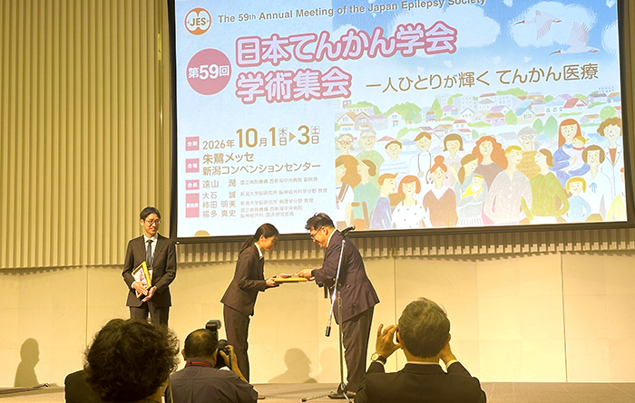 2026てんかん学会受賞式で賞状を受け取る様子