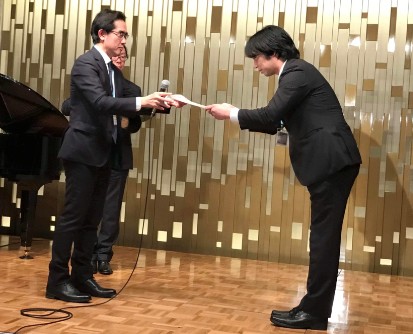 授賞式の様子 亀井 聡 大会長(左)から表彰される加藤 太郎 理学療法士(右)