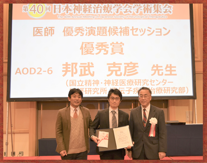 授賞式の写真 写真中央に邦武 克彦 研究員、写真左に青木 吉嗣 部長、写真右に第40回日本神経治療学会長 藤原 一男 様
